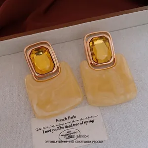 Vintage gold-framed earrings with yellow gemstones and cream marble rectangular pendants