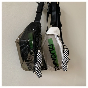 Détail de sacs bandoulière en PVC transparent avec lettrage vert et charms à damier