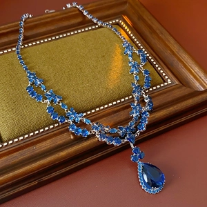 Detail of vintage double-layer necklace with blue teardrop zircon and silver chain