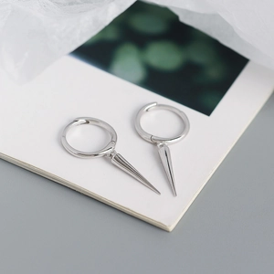 Macro view of S925 sterling silver hoop earrings with cone spike pendants on white paper