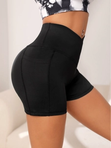 Side view of black high-waisted yoga shorts showing ergonomic stitching and slim fit