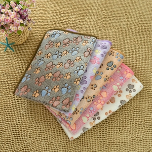 Detail of soft flannel pet blankets with paw prints in grey, purple, beige, pink and white