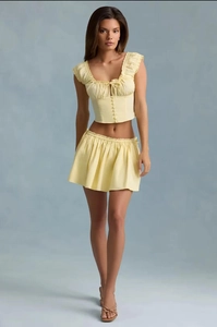Detail of light yellow floral two-piece set with ruffled crop top and matching mini skirt