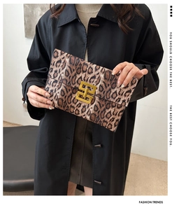 Fashion leopard print clutch bag with a golden rectangular lock held by a model in style