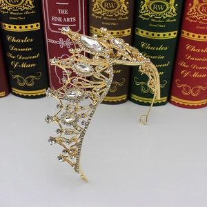Detail of golden baroque bridal crown with sparkling rhinestones on a reflective surface