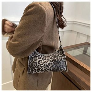 Close-up of leopard print shoulder bag with gold zipper and thin black leather strap