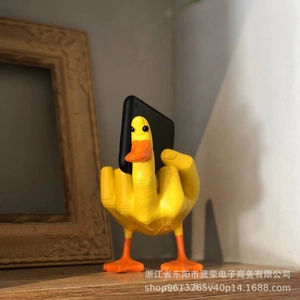 Macro detail of the yellow resin duck figurine holding a smartphone on a desk
