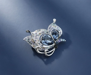 Detail of silver butterfly brooch with deep blue crystals and multicolored zircons