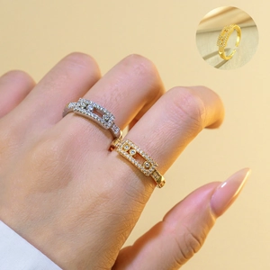 Detail of movable zircon stones on a wide band ring in gold and silver finish