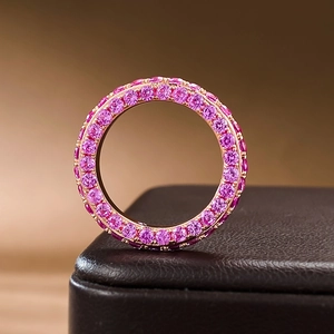 Macro shot of a rose gold ring with pink stones on a premium brown leather surface