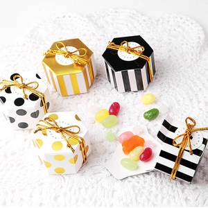 Detail showing small hexagonal gift boxes in stripe and dot patterns with gold bows
