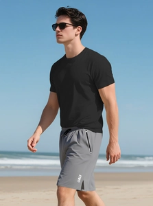 Close-up of black breathable t-shirt and grey shorts on male model at the beach