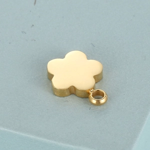 Polished gold stainless steel five-petal flower pendant charm with ring on blue background