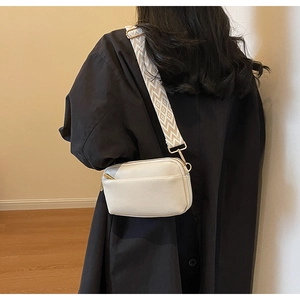 Detailed view of white PU crossbody bag featuring a stylish diamond pattern wide strap