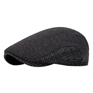 Dark grey wool flat cap with side plaid patterns and a silver metal logo plaque