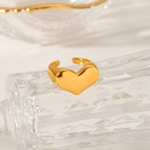 Elegant gold plated heart shaped open ring on a vintage glass dish with luxury lighting