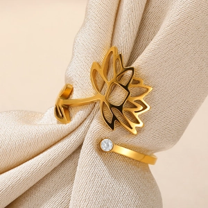 Detailed macro of golden lotus flower ring with zircon stone on beige satin fabric