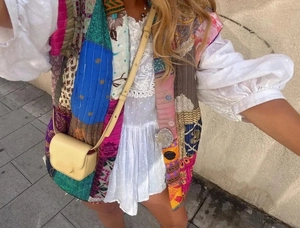 Detailed view of colorful patchwork quilted cotton vest with bohemian printed patterns