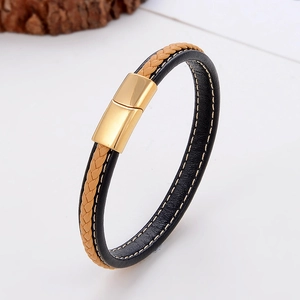 Macro detail of brown and black braided leather bracelet with golden magnetic clasp