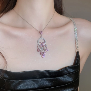 Detail of pink zircon butterfly tassel necklace on model with sparkling jewelry effect