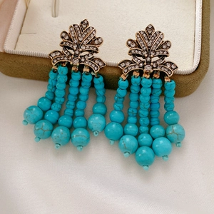Detailansicht der Vintage-Boho-Ohrringe mit Türkisperlen und goldenen Blatttasten