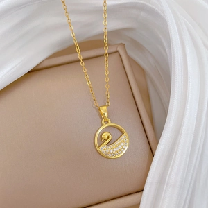 Detail of hollow swan pendant necklace with sparkling cubic zirconia on gold chain