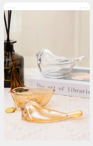 Detailed view of glass bird jewelry box in amber and clear tones for elegant storage