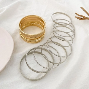 Set of ten gold and silver bangles with smooth and twisted textures for women
