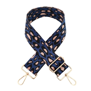 Détail de la bandoulière léopard bleu et rose avec des mousquetons en métal doré