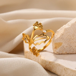 Detail of gold floral open ring with branch design and a small zircon on stone