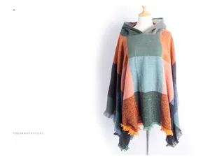 Detail of hooded plaid poncho with colorful color blocks and fringe tassels