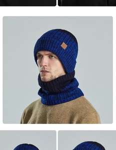 Detail van blauwe en zwarte gebreide muts en nekwarmer set met bruine lederen logopatch erop