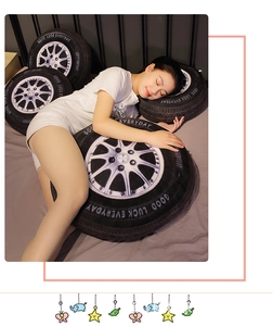 Detail of 3D tire plush cushion with 'GOOD LUCK EVERYDAY' text on a bed