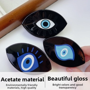 Close-up of gloss acetate evil eye hair claws with blue and white eye motifs