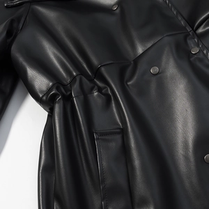 Détail d'une veste en cuir PU noir avec taille à cordon élastique et bouton en métal