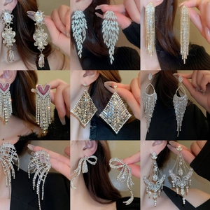 Various glamorous rhinestone drop earrings with pearls and tassels in silver finish