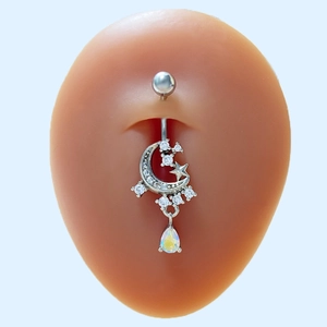 Macro shot of silver crescent moon belly ring with rainbow teardrop on a navel model