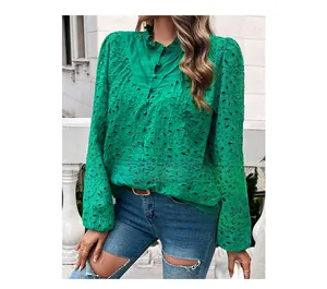 Detail of emerald green eyelet embroidery and ruffle stand collar on a women's shirt