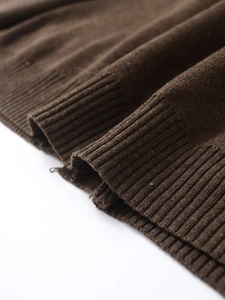 Close-up of dark brown V-neck cardigan featuring detailed ribbed knit fabric texture