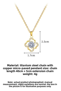 Macro shot of gold four-leaf flower necklace with sparkling white zircons and titanium chain