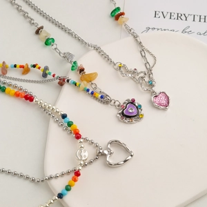 Colorful beaded heart pendant necklace with rainbow stones and silver chain layers