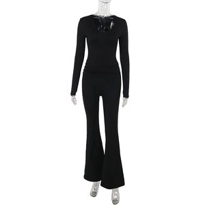 Detail view of black long sleeve set featuring V-neck lace trim and flared trousers