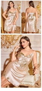 Détail de nuisette en satin doré champagne avec motifs de feuilles et baies rouges