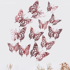 Detailed view of twelve hollow rose gold paper butterflies on a white wall with dried flowers