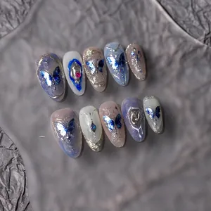 Détail d'autocollants papillon bleu avec gouttes argentées 3D et strass pour ongles