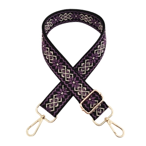 Close-up of ethnic geometric jacquard bag strap with gold metal lobster clasps