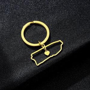 Detailed close-up of golden Puerto Rico map keychain with heart cutout on black surface