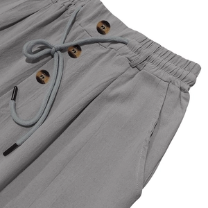 Vista macro dettagliata dei pantaloni in cotone e lino grigio chiaro con coulisse in vita