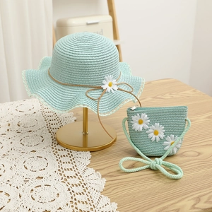 Detailed close-up of mint green straw hat and matching crossbody bag with daisy flowers