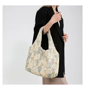 Close-up of floral print canvas tote bag on model's shoulder for casual daily commute